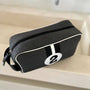 Black toiletry bag with a number two design on a bathroom counter