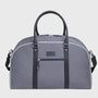 Gray duffel bag with black straps on a light gray background