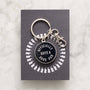 Keychain with 'Officially Quite a Good Dad' text on a gray card with white illustrations, on a light gray background.