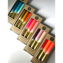 Set of colorful lip balms in packaging on a light gray background