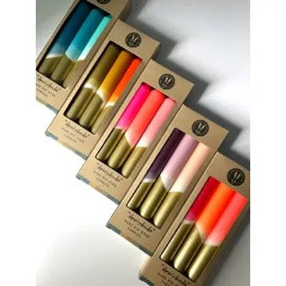 Set of colorful lip balms in packaging on a light gray background