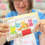 Person holding a chocolate bar with colorful packaging featuring cat illustrations.
