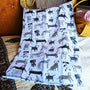 Folded blanket with black and white animal pattern on a wooden surface