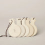 Set of four beige decorative items with strings on a light gray background
