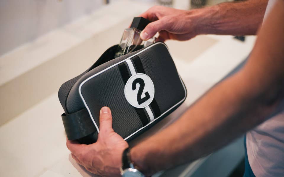 Person holding a black bag with a number 2 on it, possibly in a bathroom setting.